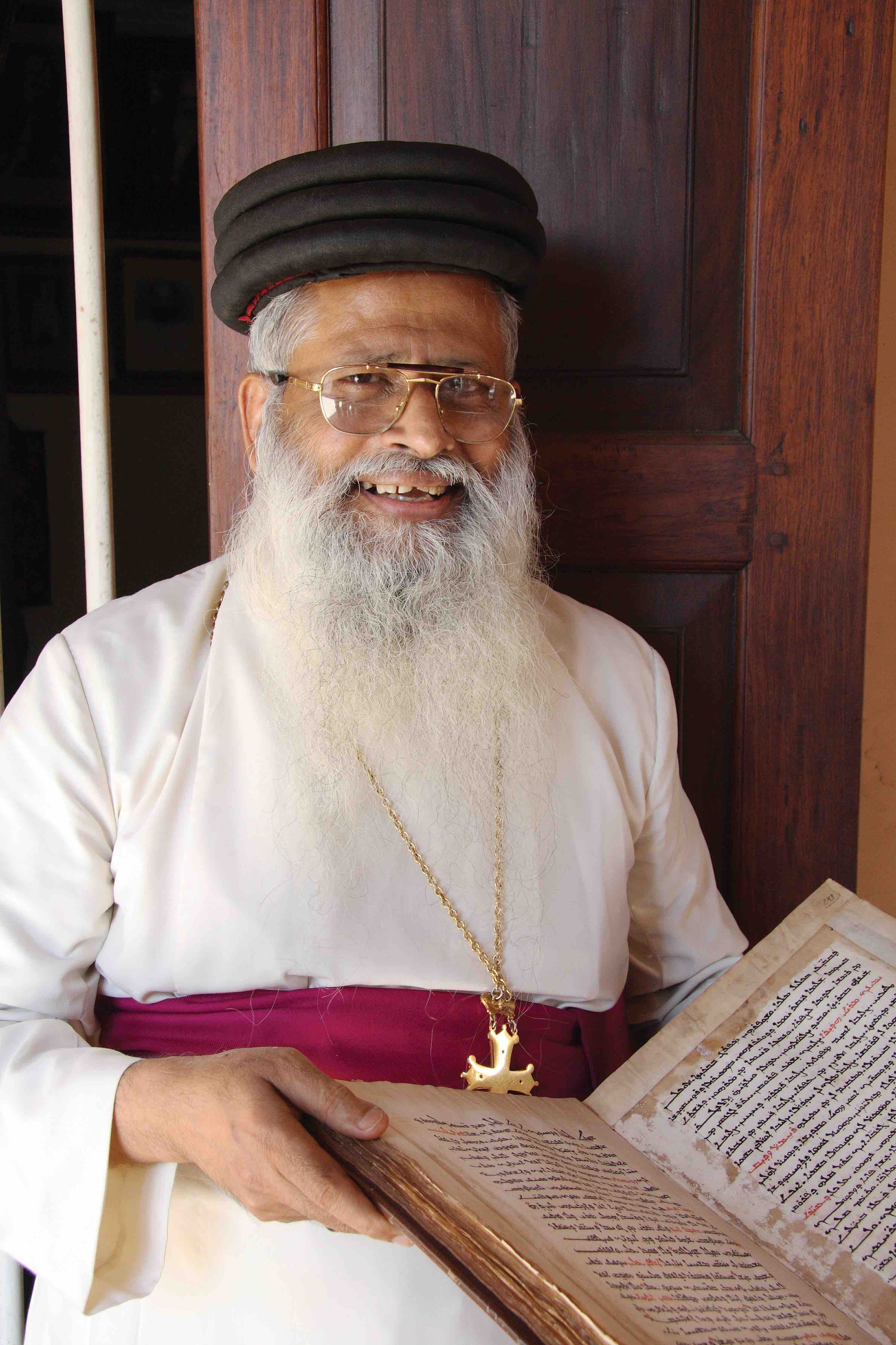 Mar Aprem Mooken, Chaldean (Assyrian Church of the East) Metropolitan of India, holding a Syriac manuscript from the collection of the Metropolitanate in Thrissur, India